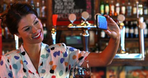Woman Taking Selfie in Pub with Glass of Wine - Download Free Stock Images Pikwizard.com