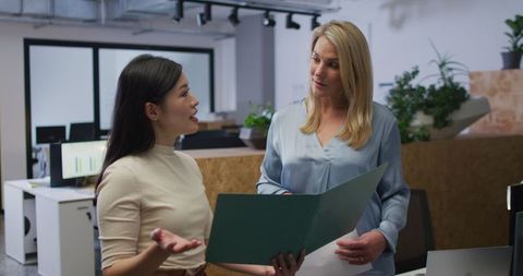 Professional Women Reviewing Documents in Modern Office