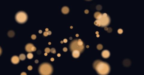 Abstract glowing orange light spots on black background