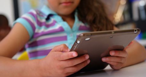 Young schoolgirl focused on digital tablet in classroom