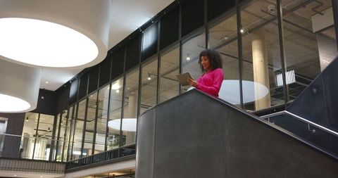 African american businesswoman using tablet in modern office interior