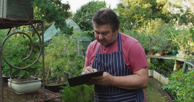 Man in Garden Writing on Clipboard - Download Free Stock Images Pikwizard.com