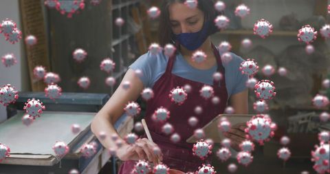 Safe creative activity: woman painting pottery with virus overlay