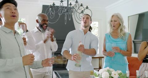 Multigenerational Group Celebrating with Champagne Toast Indoors