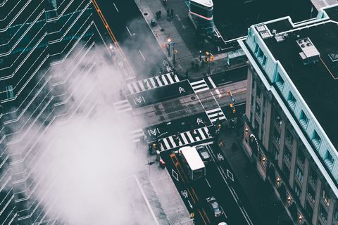 Aerial view of urban crosswalk with city traffic and steam