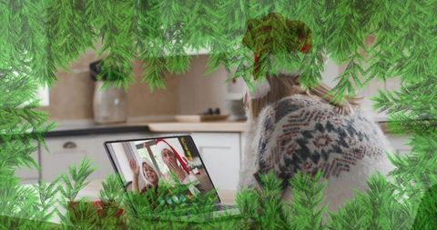 Woman video calling friends for virtual christmas celebration