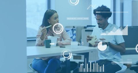 Colleagues discussing work during lunch break in modern office