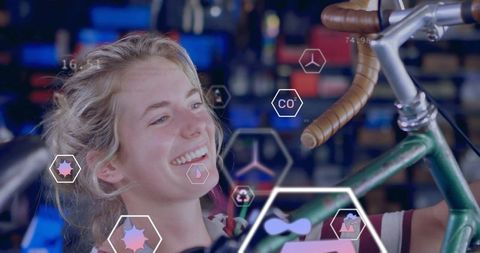 Smiling woman inspecting bike frame with augmented reality diagnostics in repair shop