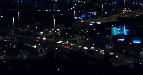 Curved highway interchange with light trails at night