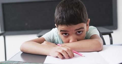 Young Student Thinking Intently at School Desk - Download Free Stock Images Pikwizard.com