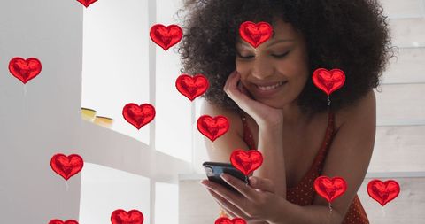 Happy woman enjoying social media with heart icons overlay