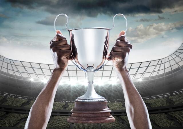 Digital composition of hands holding a champion trophy in stadium