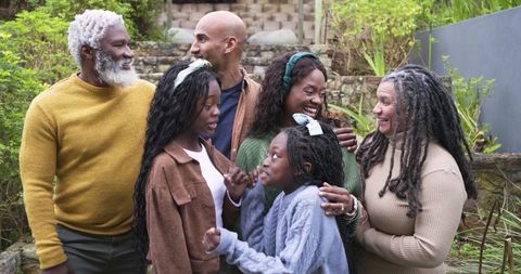 Multigenerational Multiracial Family Celebrating Engagement in Garden Backyard Embracing
