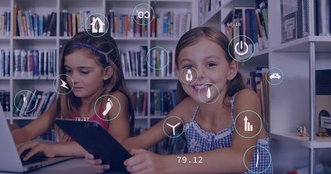 Smiling schoolgirls using tablet and laptop in library with augmented learning hud overlay