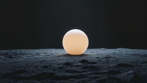 Glowing spherical orb on cratered terrain in futuristic ambiance