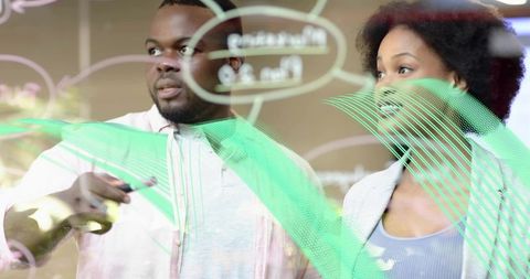 Collaborating on glass whiteboard brainstorming with marker sketches and diagrams