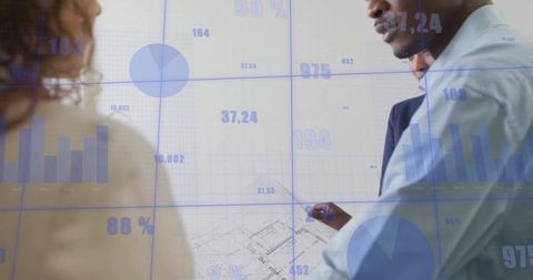 Business Team Analyzing Plans with Data Visualization Projections in Office