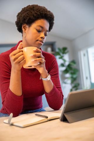 Focused African American Woman Relaxing with Coffee Tablet Notebook