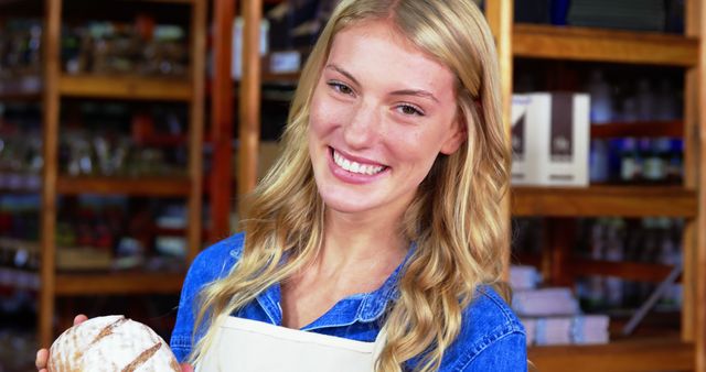 Smiling Woman Holding Freshly Baked Artisan Bread in Bakery - Download Free Stock Images Pikwizard.com