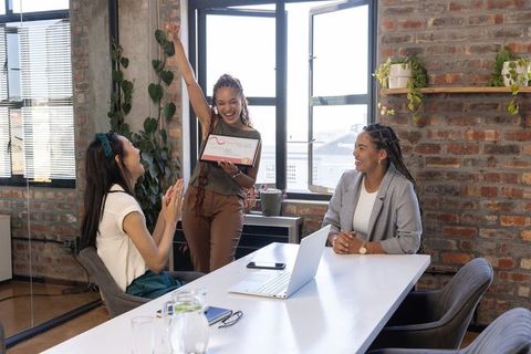 Celebrating Achievement in Modern Office With Female Coworkers