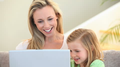 Mother and Daughter Using Laptop Smiling