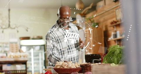 Senior man using smartphone for augmented reality shopping while selecting mushrooms