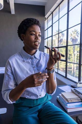 Businesswoman Engaging in Smartphone Conversation in Modern Office