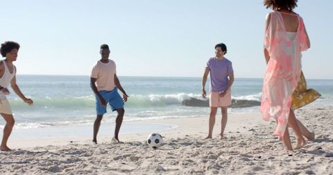 Diverse Teenagers Enjoying Beach Soccer in Sunlight