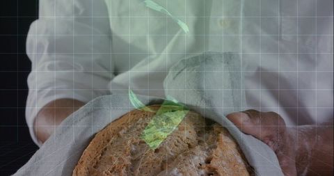 Cradling rustic artisan loaf wrapped in linen by home baker presenting fresh bread