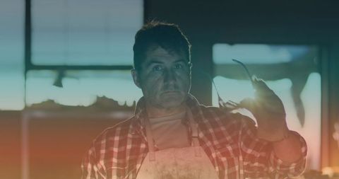 Worker wearing safety goggles in workshop with light spot effect