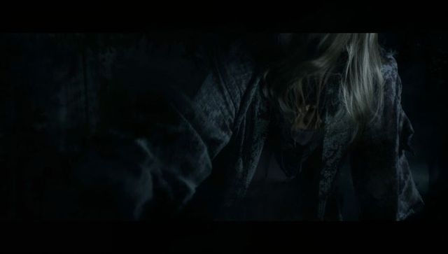 Enigmatic Woman Reaching Out in Dimly Lit Room