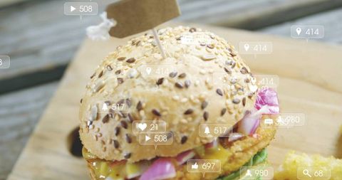 Seeded burger with fries and social media engagement icons close-up for foodie content