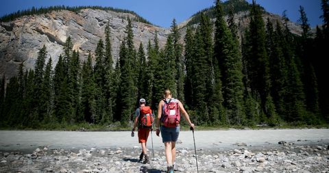 Caucasian Couple Hiking in Scenic Mountain Forest Near Riverside