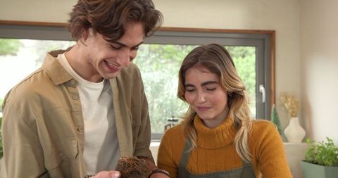 Couple cooking together with fresh root vegetable in home kitchen