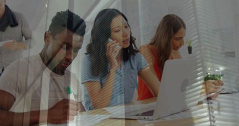 Diverse team collaborating with digital tools in modern office