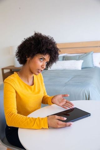 African American Woman Focused on Tablet in Modern Bedroom