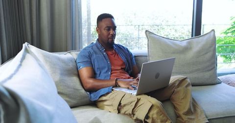 Man Relaxing in Modern Home Using Laptop