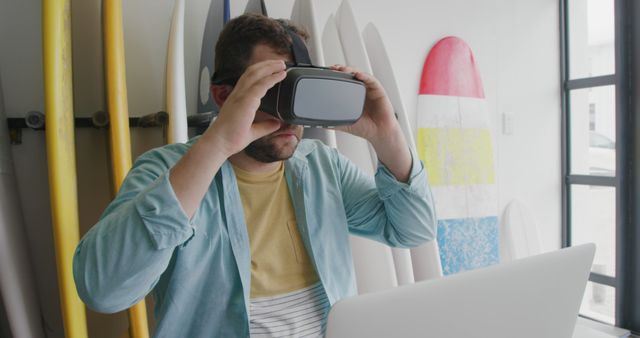 Man Using Virtual Reality Headset while Surfboards are in Background - Download Free Stock Images Pikwizard.com