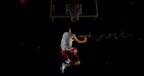 Dynamic basketball player dunking on dark court