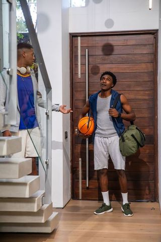 Friends Chatting in Urban Foyer with Sports Gear and Basketball