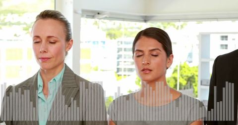 Two women meditating with audio equalizer overlay in modern office