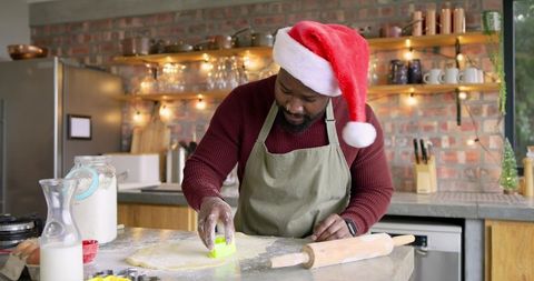 African American Man Wearing Santa Hat Baking Holiday Cookies in Cozy Festive Kitchen