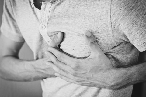 Man in pain holding chest with both hands