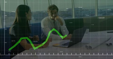 Two professionals analyzing green growth chart over plans and laptop in highrise office