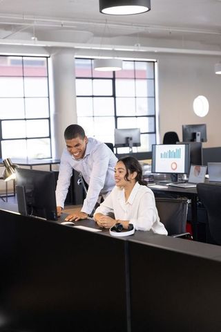 Diverse Coworkers Collaborating on Desktop in Modern Office