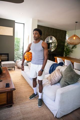 Athletic Man Holding Basketball in Contemporary Living Room