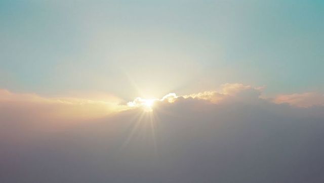 Serene Sunrise With Sunburst Over Soft Cloud Horizon