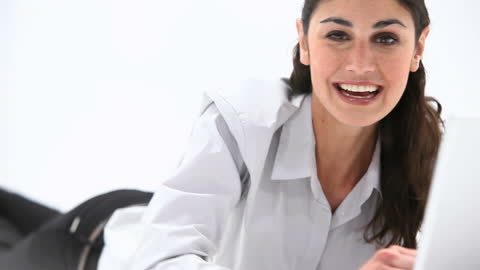 Smiling Woman Reclining While Using a Laptop at Home