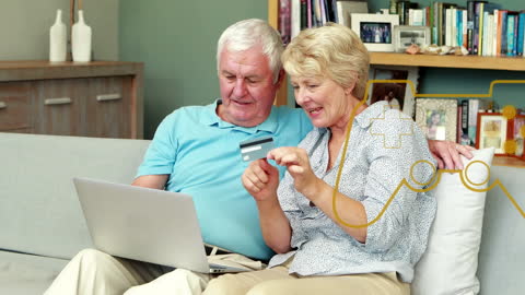 Senior Couple Shopping Online with Credit Card on Couch