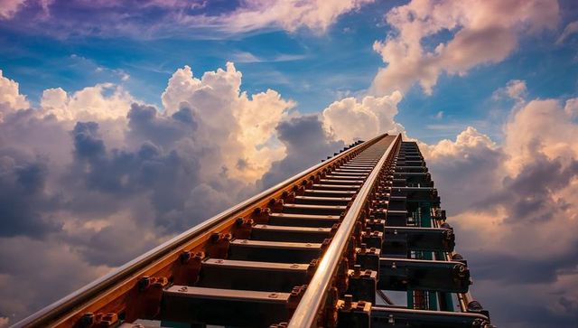 Dynamic steel rails ascending towards dramatic cloud-filled sky